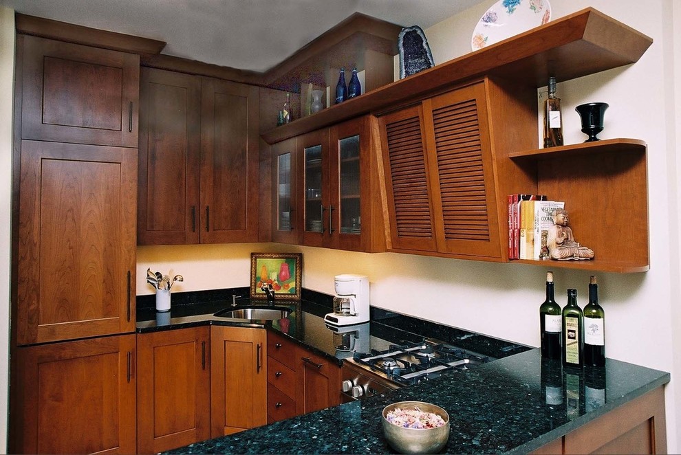 Photo of a traditional u-shaped kitchen/diner in New York with a submerged sink, recessed-panel cabinets, medium wood cabinets, granite worktops, stone slab splashback and integrated appliances.