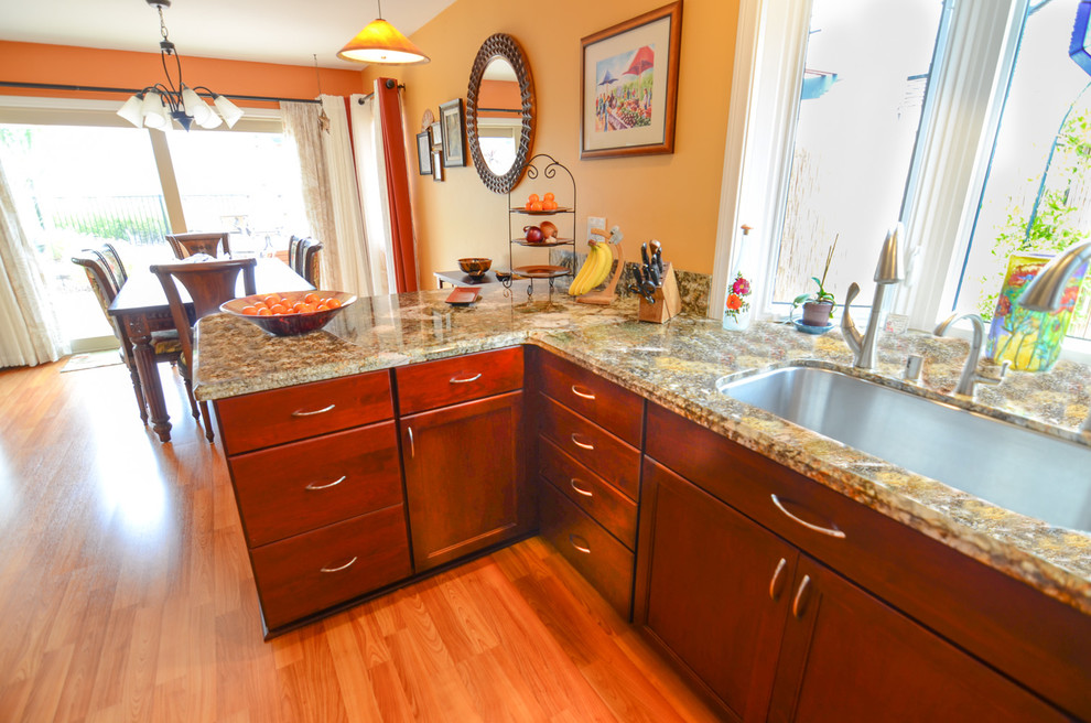 Inspiration for a large contemporary galley medium tone wood floor eat-in kitchen remodel in Tampa with a single-bowl sink, recessed-panel cabinets, red cabinets, granite countertops, yellow backsplash, glass tile backsplash and stainless steel appliances