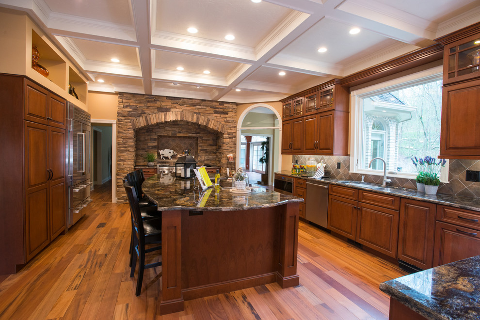 Bild på ett funkis kök, med en undermonterad diskho, luckor med upphöjd panel, skåp i mellenmörkt trä, granitbänkskiva, flerfärgad stänkskydd, stänkskydd i keramik, rostfria vitvaror, mellanmörkt trägolv och en köksö