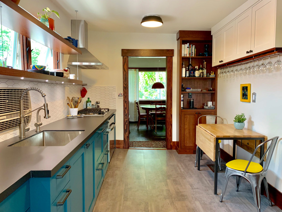 Example of a small eclectic galley vinyl floor and gray floor enclosed kitchen design in Salt Lake City with an undermount sink, shaker cabinets, white backsplash, ceramic backsplash, stainless steel appliances and black countertops