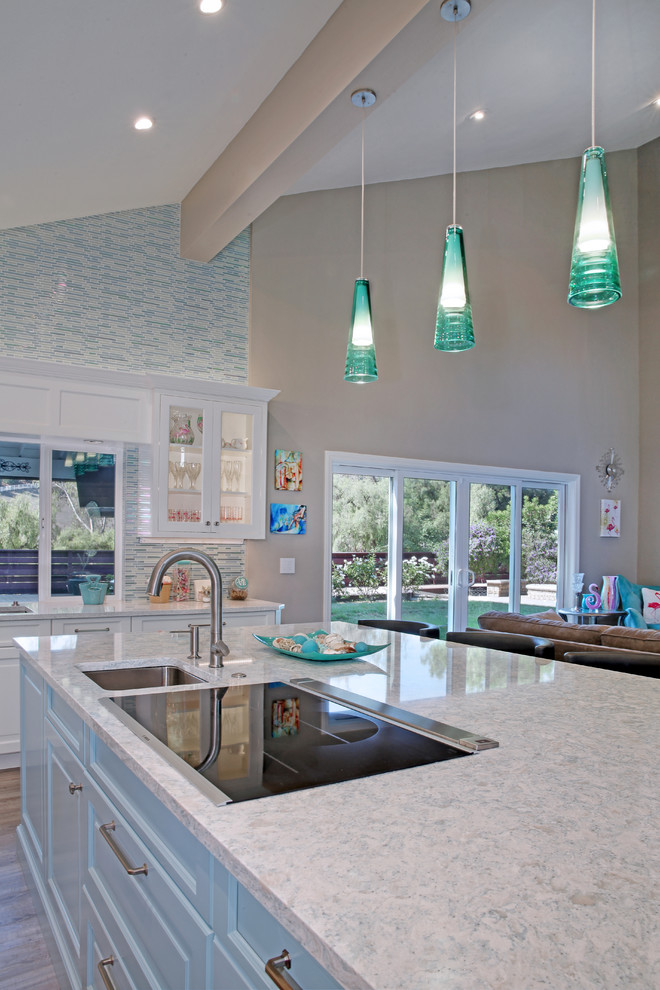 Large eclectic l-shaped vinyl floor and gray floor open concept kitchen photo in Orange County with a single-bowl sink, recessed-panel cabinets, white cabinets, quartz countertops, multicolored backsplash, glass tile backsplash, stainless steel appliances and an island