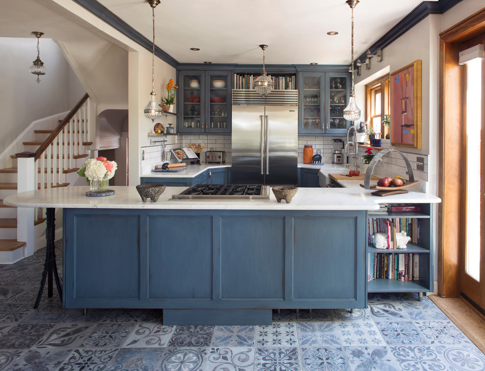 Klassisk inredning av ett mellanstort vit vitt kök, med en rustik diskho, öppna hyllor, blå skåp, bänkskiva i kvarts, vitt stänkskydd, stänkskydd i tunnelbanekakel, rostfria vitvaror, klinkergolv i keramik, en köksö och blått golv