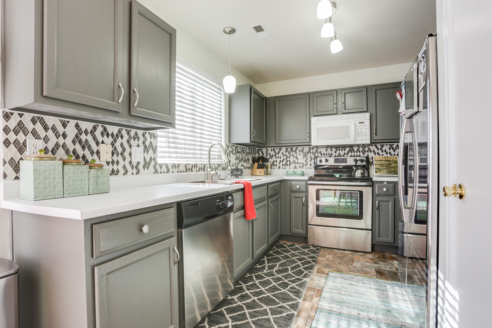 Mid-sized eclectic u-shaped travertine floor and brown floor enclosed kitchen photo in Other with a double-bowl sink, shaker cabinets, gray cabinets, laminate countertops, multicolored backsplash, ceramic backsplash and stainless steel appliances