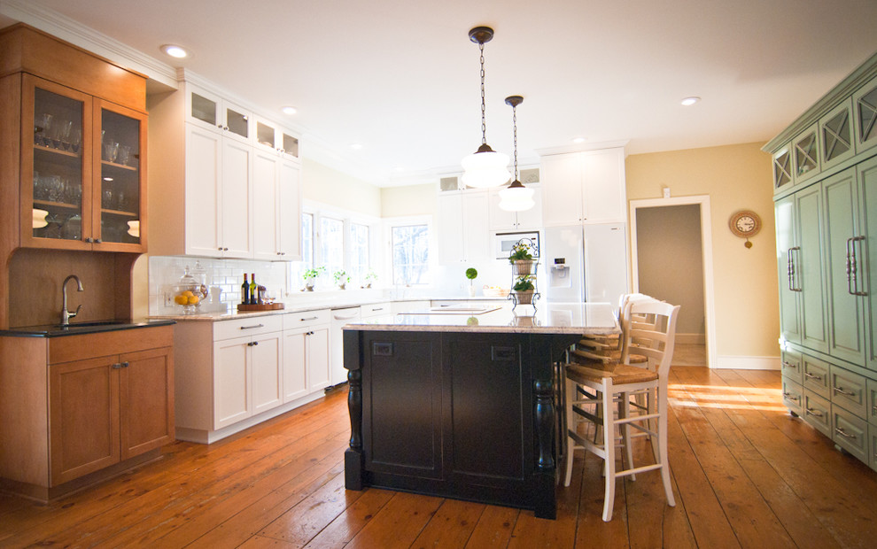 Example of a mid-sized eclectic l-shaped medium tone wood floor and orange floor eat-in kitchen design in Grand Rapids with an undermount sink, raised-panel cabinets, white cabinets, granite countertops, white backsplash, ceramic backsplash, white appliances, an island and beige countertops