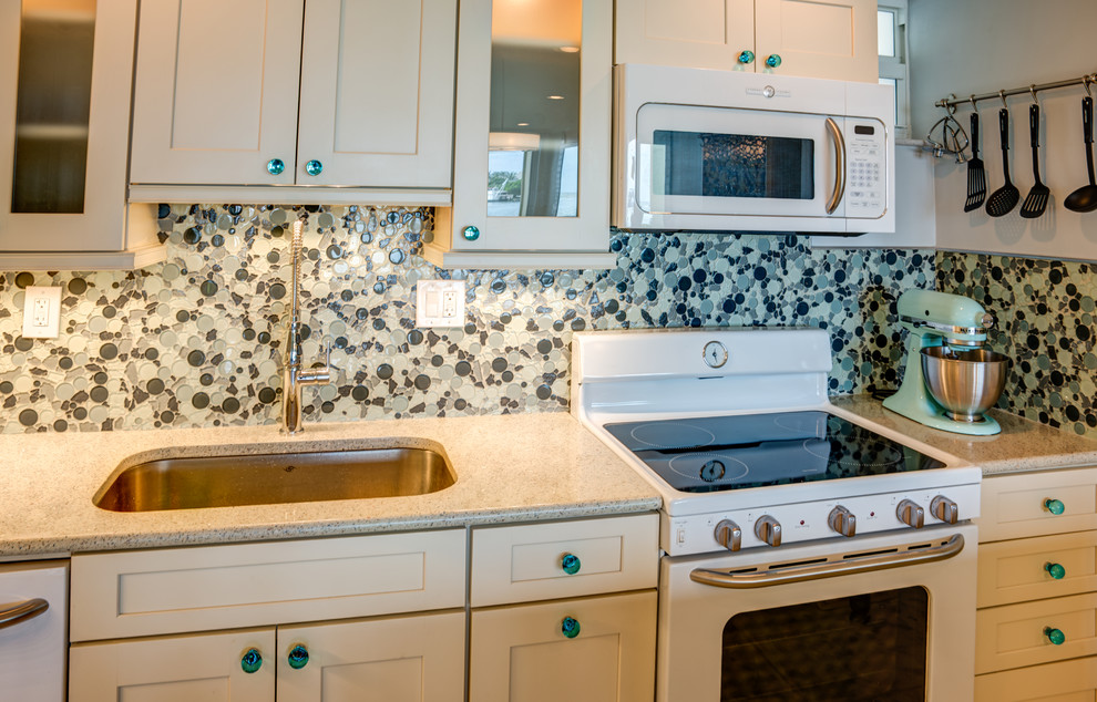 Exempel på ett avskilt, litet eklektiskt l-kök, med en undermonterad diskho, skåp i shakerstil, vita skåp, bänkskiva i kvarts, flerfärgad stänkskydd, stänkskydd i glaskakel, vita vitvaror, marmorgolv, en köksö och grått golv