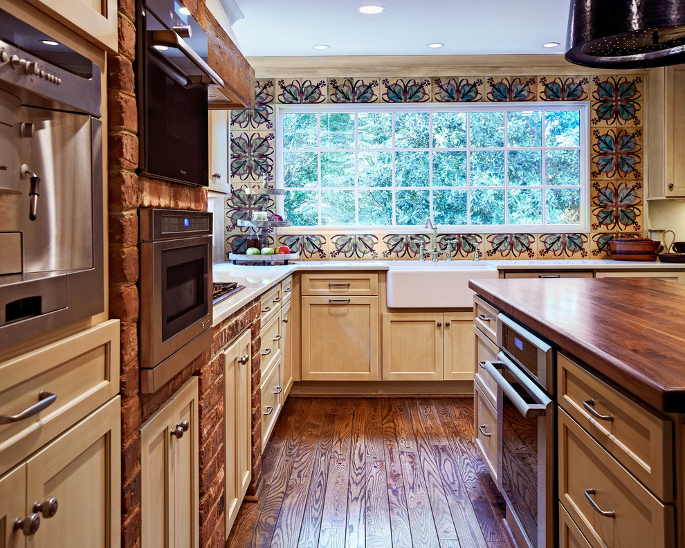 Пример оригинального дизайна: угловая кухня в классическом стиле с разноцветным фартуком, с полувстраиваемой мойкой (с передним бортиком), фасадами с утопленной филенкой, светлыми деревянными фасадами и техникой из нержавеющей стали