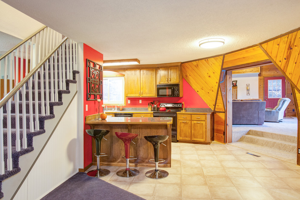 Eklektische Küche mit hellbraunen Holzschränken, Küchenrückwand in Grau und schwarzen Elektrogeräten in Minneapolis