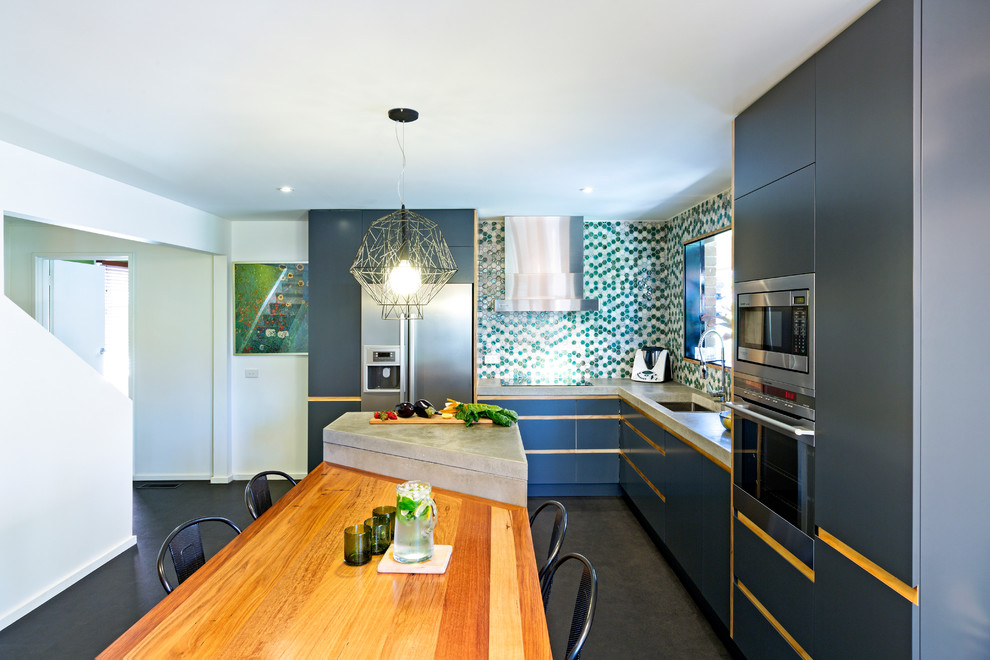 Inspiration for an eclectic l-shaped eat-in kitchen remodel in Melbourne with an undermount sink, flat-panel cabinets, gray cabinets, multicolored backsplash, mosaic tile backsplash, stainless steel appliances and an island