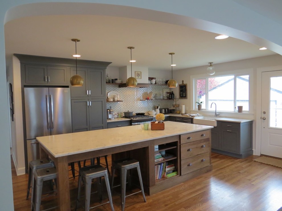 Eat-in kitchen - eclectic l-shaped medium tone wood floor eat-in kitchen idea in Chicago with a farmhouse sink, shaker cabinets, gray cabinets, quartz countertops, white backsplash, ceramic backsplash, stainless steel appliances and an island