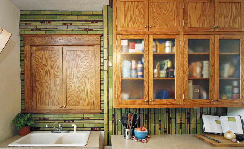 Inspiration för avskilda, små eklektiska l-kök, med en nedsänkt diskho, luckor med infälld panel, flerfärgad stänkskydd, stänkskydd i mosaik, vita vitvaror, mellanmörkt trägolv och skåp i mellenmörkt trä