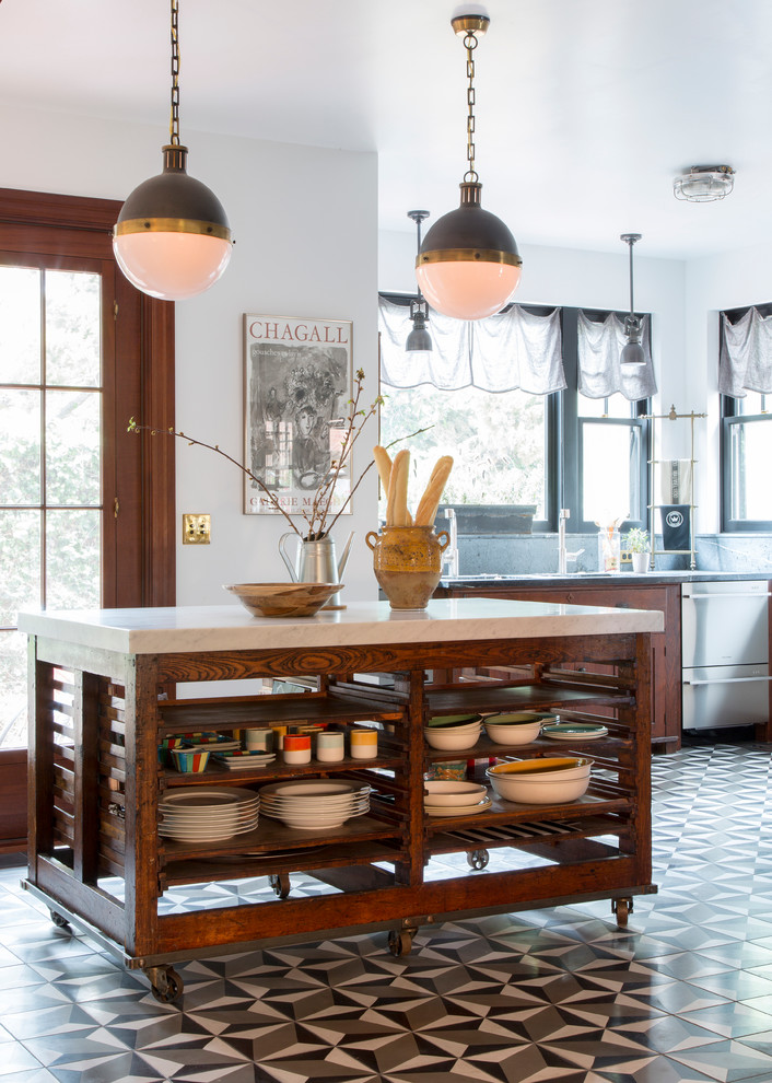 Ejemplo de cocina bohemia con puertas de armario de madera en tonos medios, electrodomésticos de acero inoxidable y una isla