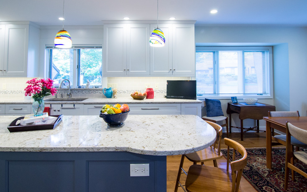 Large eclectic l-shaped medium tone wood floor and brown floor eat-in kitchen photo in Philadelphia with an undermount sink, recessed-panel cabinets, white cabinets, quartz countertops, multicolored backsplash, ceramic backsplash, stainless steel appliances, an island and beige countertops