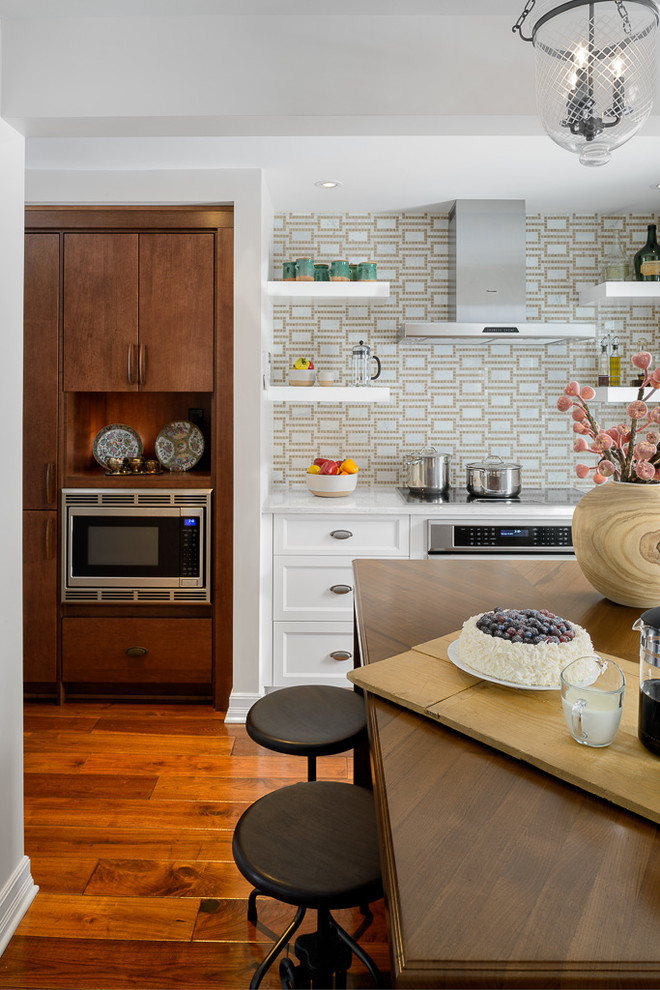 Example of a large transitional medium tone wood floor eat-in kitchen design in Ottawa with a farmhouse sink, white cabinets, beige backsplash, stainless steel appliances and an island