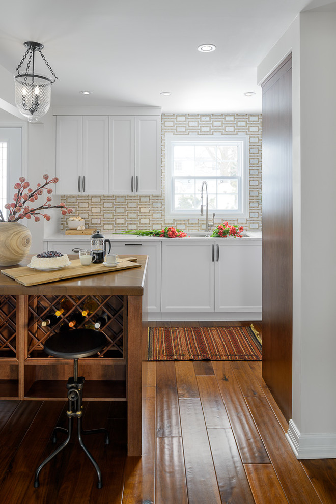 Inspiration for a large transitional medium tone wood floor eat-in kitchen remodel in Ottawa with a farmhouse sink, white cabinets, beige backsplash, stainless steel appliances and an island