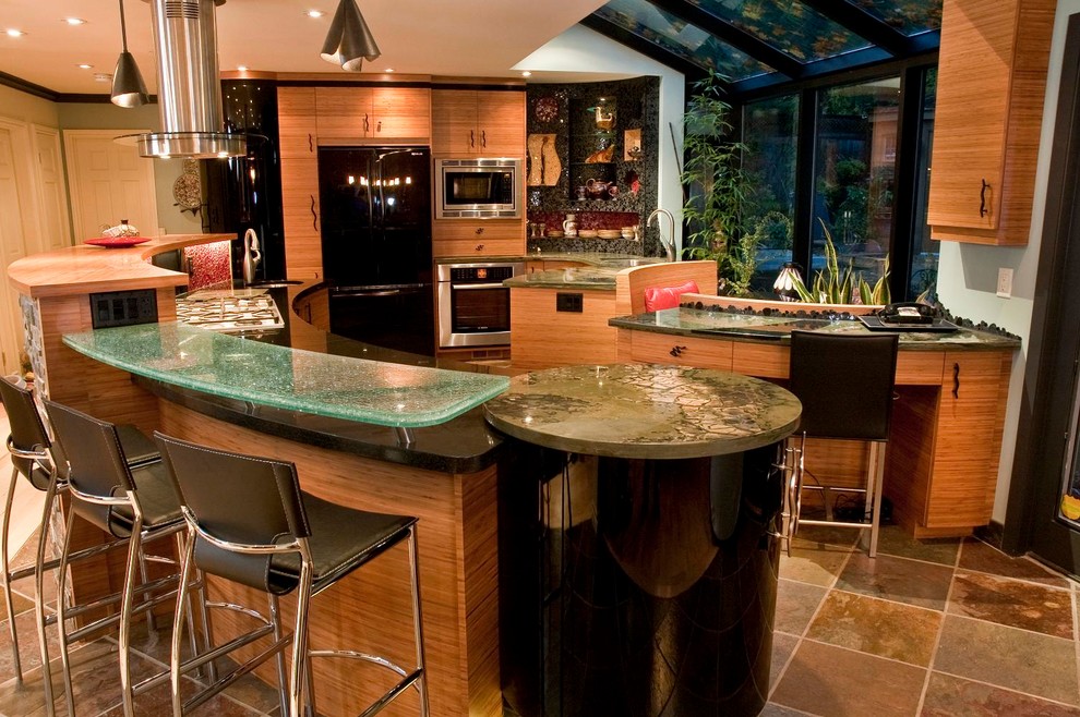 トロントにあるコンテンポラリースタイルのおしゃれなキッチン (フラットパネル扉のキャビネット、淡色木目調キャビネット、黒い調理設備) の写真