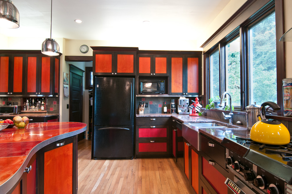 Stilmix Küche mit Doppelwaschbecken, roten Schränken, Laminat-Arbeitsplatte, schwarzen Elektrogeräten und roter Arbeitsplatte in Seattle