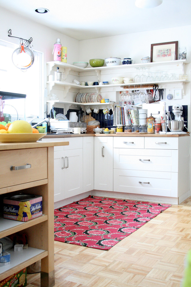 Enclosed kitchen - eclectic enclosed kitchen idea in Burlington with open cabinets, white cabinets and wood countertops