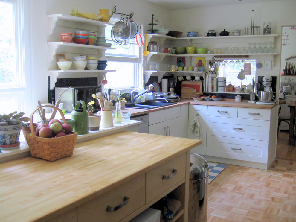Kitchen - eclectic kitchen idea in Burlington with wood countertops and open cabinets