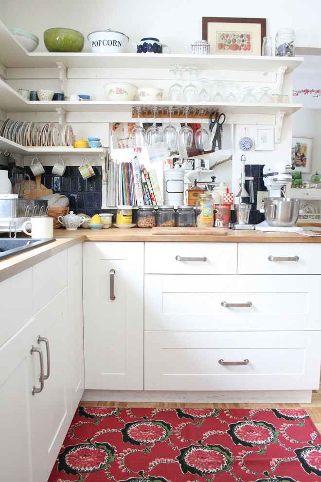 Eclectic kitchen photo in Burlington with wood countertops, open cabinets, white cabinets and blue backsplash