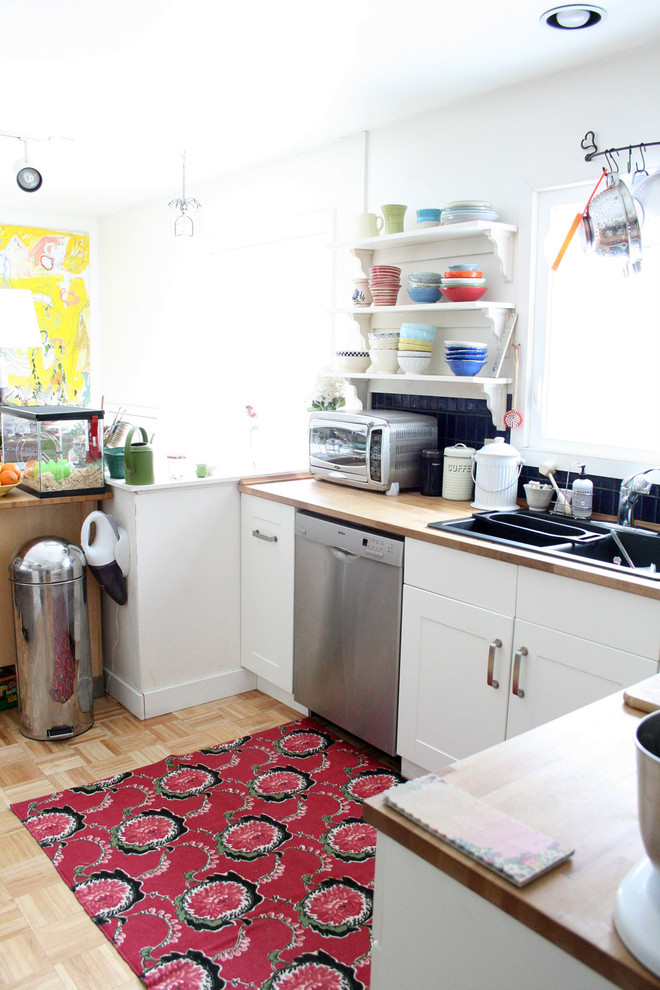 Exempel på ett eklektiskt kök, med träbänkskiva, en nedsänkt diskho, öppna hyllor, vita skåp, blått stänkskydd och rostfria vitvaror