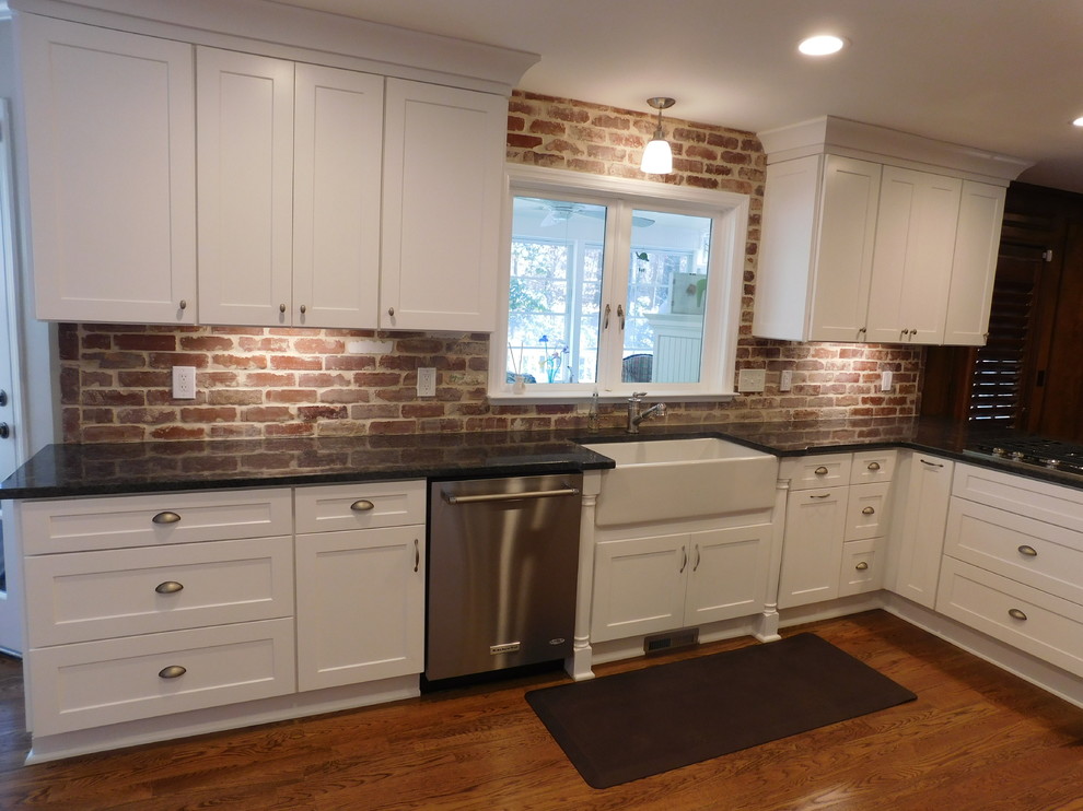 Bild på ett mellanstort eklektiskt kök, med en rustik diskho, skåp i shakerstil, vita skåp, granitbänkskiva, rött stänkskydd, rostfria vitvaror, mellanmörkt trägolv och en halv köksö
