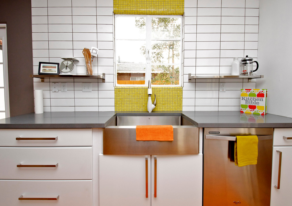Exempel på ett eklektiskt kök, med en rustik diskho, släta luckor, vita skåp, bänkskiva i kvarts, gult stänkskydd, stänkskydd i mosaik och rostfria vitvaror