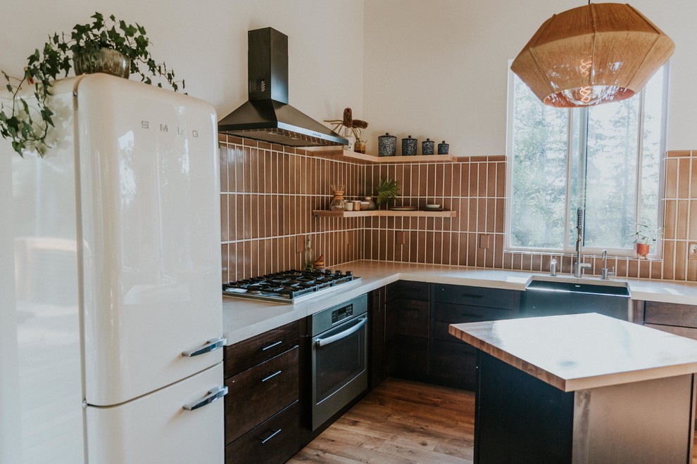 Foto di una cucina nordica di medie dimensioni con ante in legno bruno, paraspruzzi marrone, paraspruzzi con piastrelle in ceramica, elettrodomestici in acciaio inossidabile, pavimento in legno massello medio, pavimento marrone e top bianco