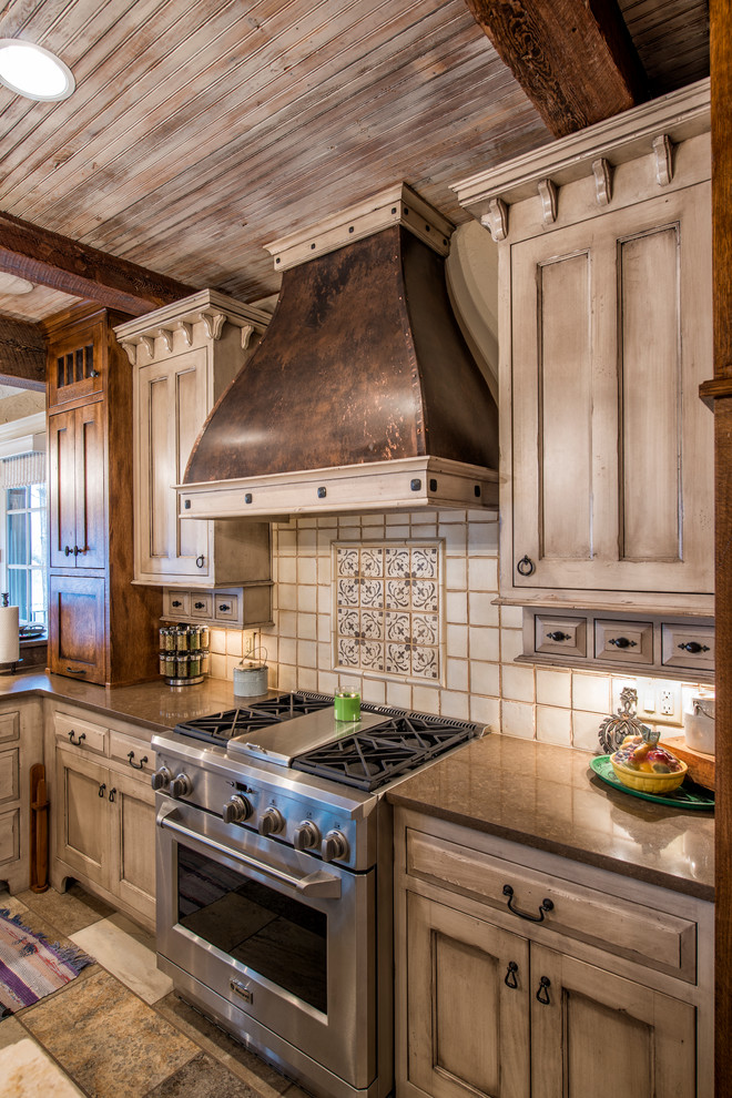 Foto på ett stort rustikt u-kök, med en rustik diskho, skåp i shakerstil, skåp i slitet trä, bänkskiva i kvarts, vitt stänkskydd, stänkskydd i porslinskakel, rostfria vitvaror, klinkergolv i porslin och en köksö