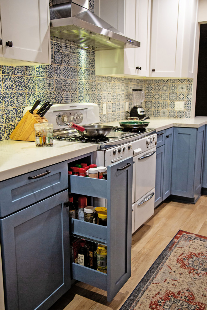 Eat-in kitchen - mid-sized eclectic l-shaped laminate floor and beige floor eat-in kitchen idea in Los Angeles with an undermount sink, shaker cabinets, blue cabinets, quartz countertops, blue backsplash, porcelain backsplash, stainless steel appliances, an island and white countertops