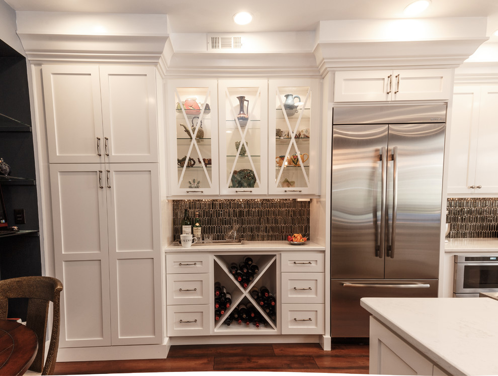 Bild på ett mellanstort eklektiskt kök, med en undermonterad diskho, skåp i shakerstil, bänkskiva i kvarts, grått stänkskydd, stänkskydd i glaskakel, rostfria vitvaror, mörkt trägolv, en köksö, brunt golv och vita skåp
