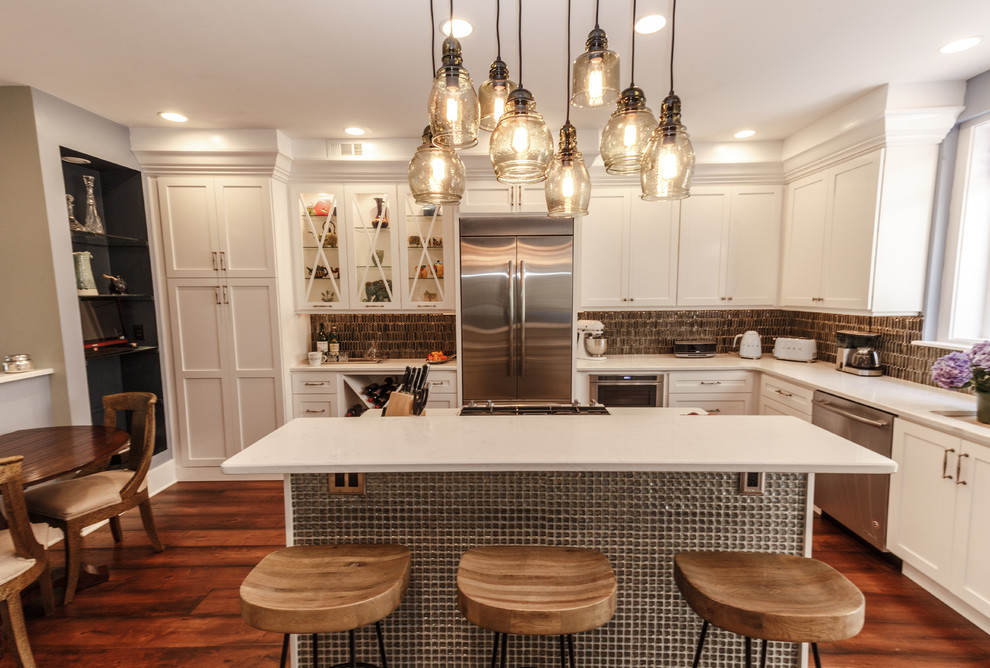 Example of a mid-sized eclectic l-shaped dark wood floor and brown floor eat-in kitchen design in Philadelphia with an undermount sink, shaker cabinets, quartz countertops, gray backsplash, glass tile backsplash, stainless steel appliances, an island and white cabinets