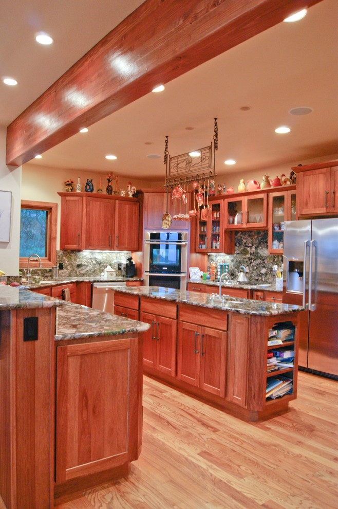 Cette photo montre une cuisine chic en U et bois brun avec un placard à porte shaker, une crédence multicolore et un électroménager en acier inoxydable.