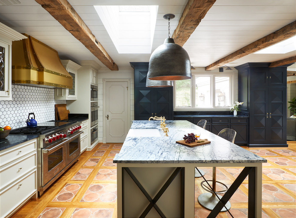 Foto på ett eklektiskt kök, med en rustik diskho, luckor med infälld panel, vita skåp, vitt stänkskydd, rostfria vitvaror, klinkergolv i terrakotta, en köksö och orange golv