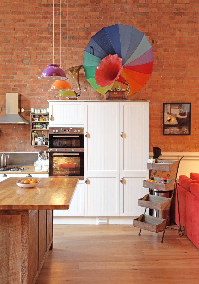 Immagine di una cucina bohémian di medie dimensioni con ante in stile shaker, ante bianche, top in legno, paraspruzzi a effetto metallico e elettrodomestici in acciaio inossidabile