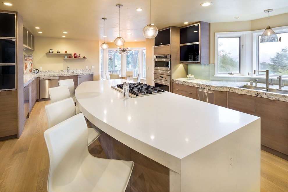 Foto på ett stort eklektiskt kök och matrum, med en undermonterad diskho, släta luckor, skåp i ljust trä, bänkskiva i kvarts, rostfria vitvaror och en köksö