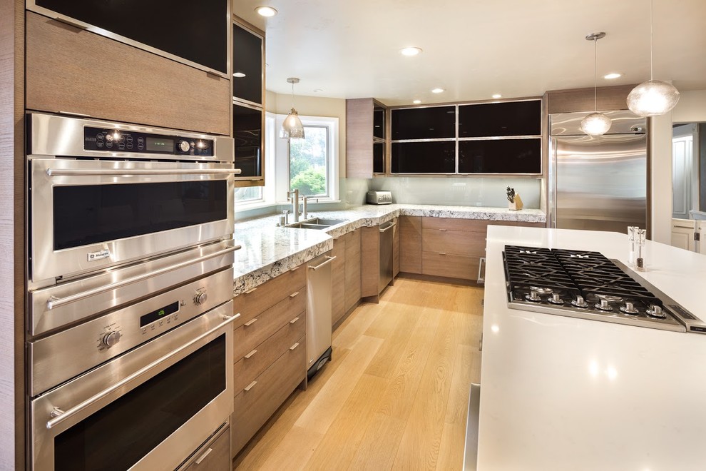 サンフランシスコにある高級な広いエクレクティックスタイルのおしゃれなキッチン (アンダーカウンターシンク、フラットパネル扉のキャビネット、淡色木目調キャビネット、クオーツストーンカウンター、シルバーの調理設備) の写真
