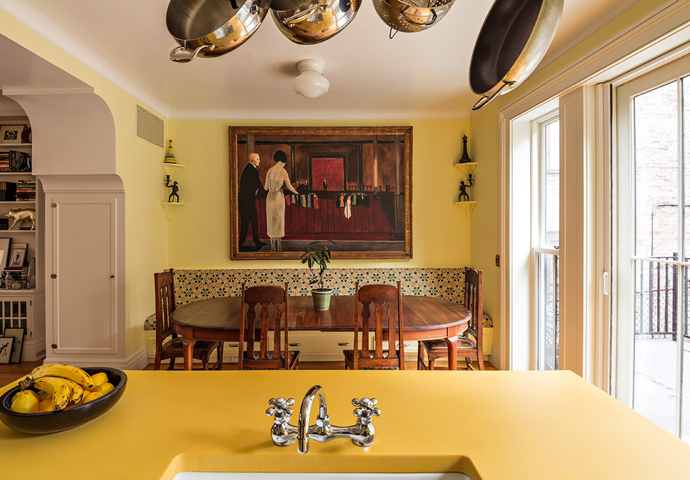 Idéer för ett mellanstort klassiskt linjärt kök och matrum, med en rustik diskho, skåp i shakerstil, gula skåp, bänkskiva i återvunnet glas, vitt stänkskydd, stänkskydd i keramik, färgglada vitvaror, mellanmörkt trägolv, en köksö och orange golv