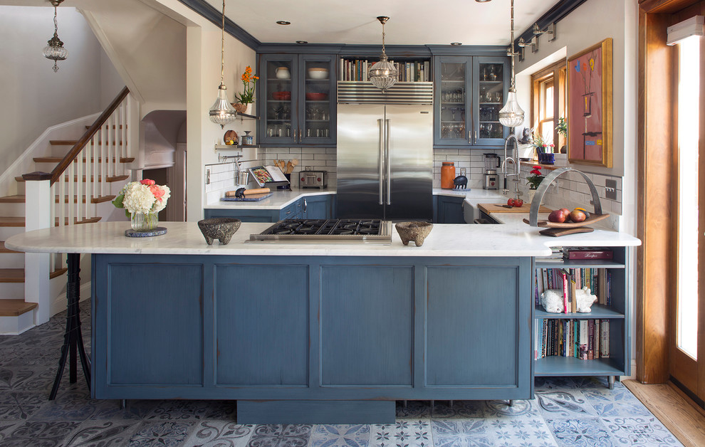 Idéer för att renovera ett mellanstort vintage vit vitt kök med öppen planlösning, med en rustik diskho, luckor med glaspanel, blå skåp, marmorbänkskiva, vitt stänkskydd, stänkskydd i keramik, rostfria vitvaror, klinkergolv i keramik och blått golv