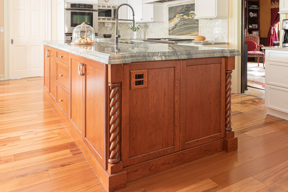 Example of a large transitional u-shaped medium tone wood floor and brown floor eat-in kitchen design in Philadelphia with an undermount sink, white cabinets, quartzite countertops, white backsplash, two islands and multicolored countertops