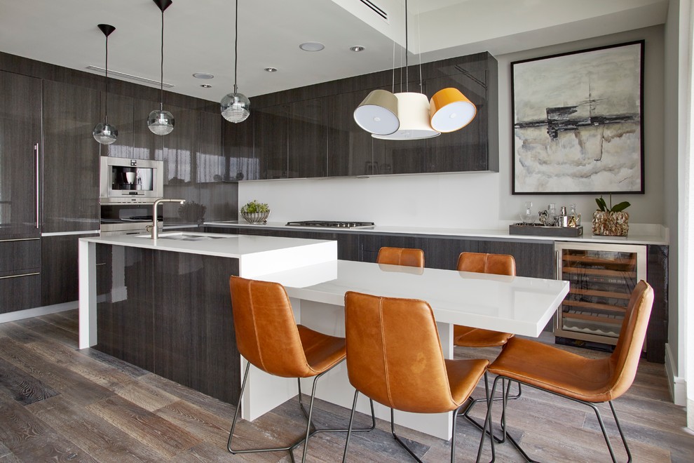 Contemporary kitchen in Miami with a submerged sink, flat-panel cabinets, white splashback, stainless steel appliances, dark hardwood flooring and an island.
