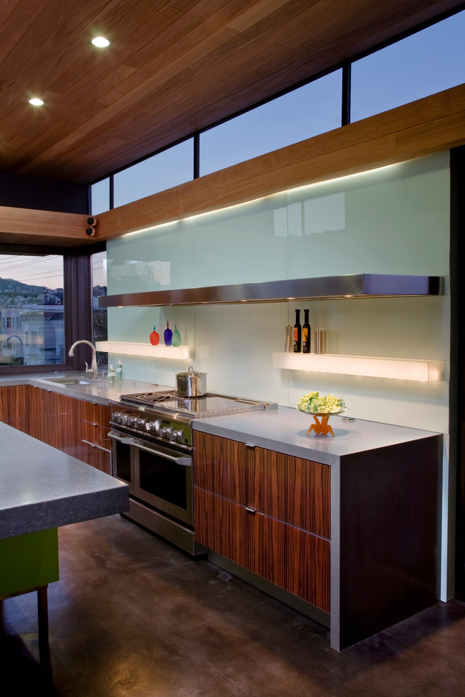 サンフランシスコにあるコンテンポラリースタイルのおしゃれなキッチン (コンクリートカウンター、シルバーの調理設備、ガラス板のキッチンパネル) の写真