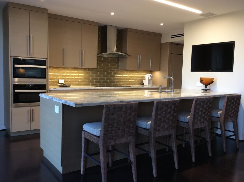 Photo of a medium sized contemporary single-wall kitchen in Orange County with a submerged sink, flat-panel cabinets, grey cabinets, marble worktops, glass tiled splashback, integrated appliances, dark hardwood flooring and a breakfast bar.