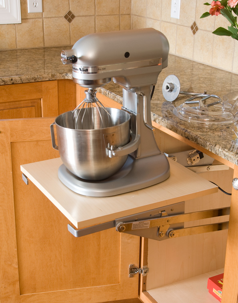 Exempel på ett klassiskt kök, med luckor med upphöjd panel, skåp i ljust trä, granitbänkskiva, beige stänkskydd, stänkskydd i keramik, rostfria vitvaror och ljust trägolv