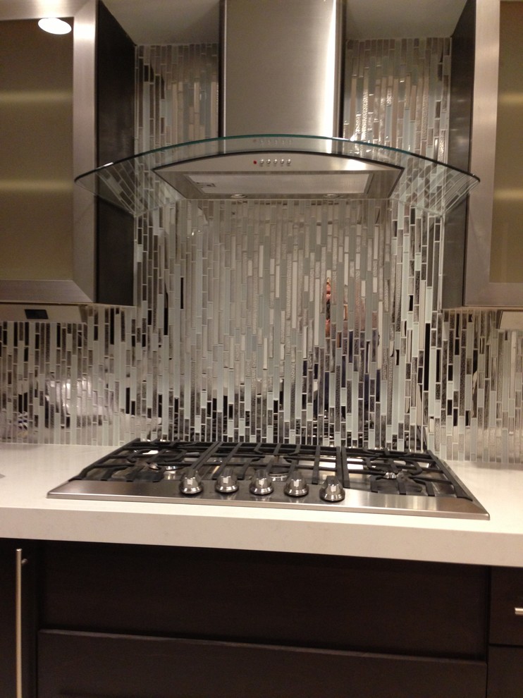 Immagine di una cucina abitabile contemporanea con paraspruzzi con piastrelle di vetro