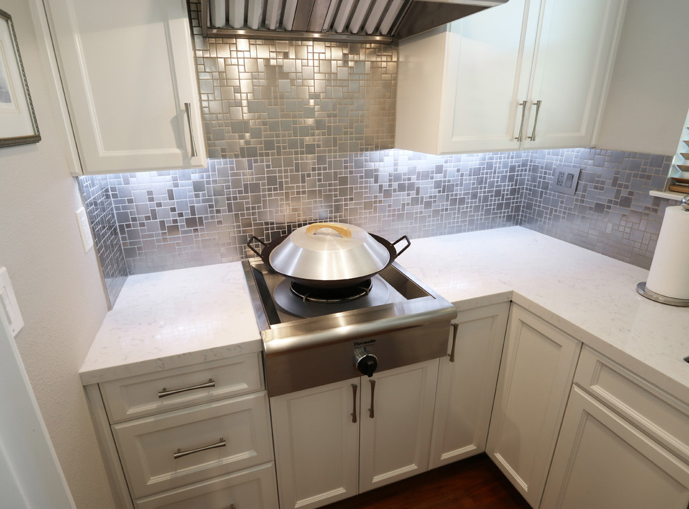 Bild på ett funkis kök och matrum, med stänkskydd i metallkakel