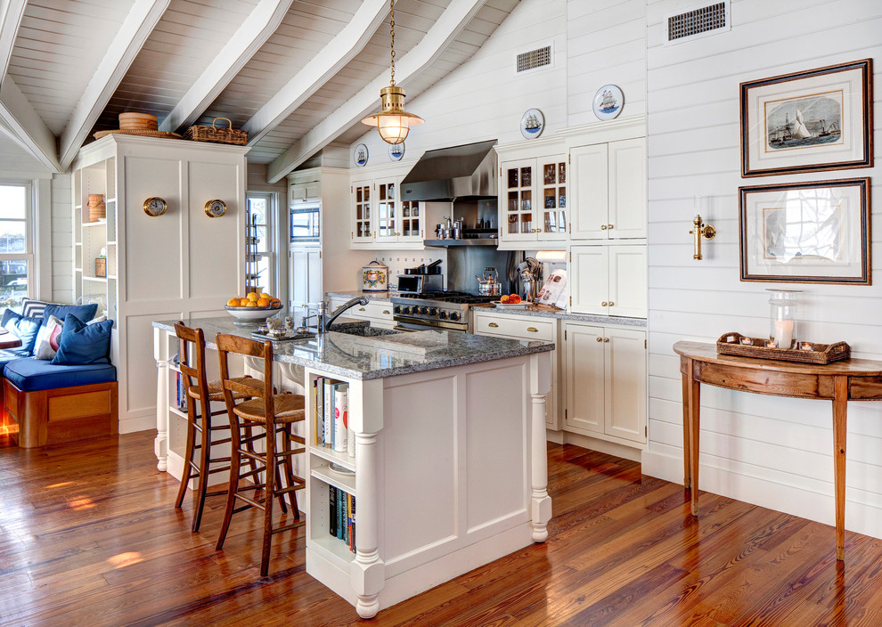Modelo de cocina comedor marinera con armarios con paneles empotrados, puertas de armario blancas y electrodomésticos de acero inoxidable