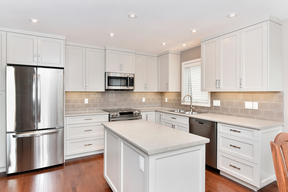 Inspiration for a medium sized traditional l-shaped kitchen in Calgary with shaker cabinets, beige cabinets, laminate countertops, ceramic splashback, stainless steel appliances, medium hardwood flooring, an island, a double-bowl sink and grey splashback.