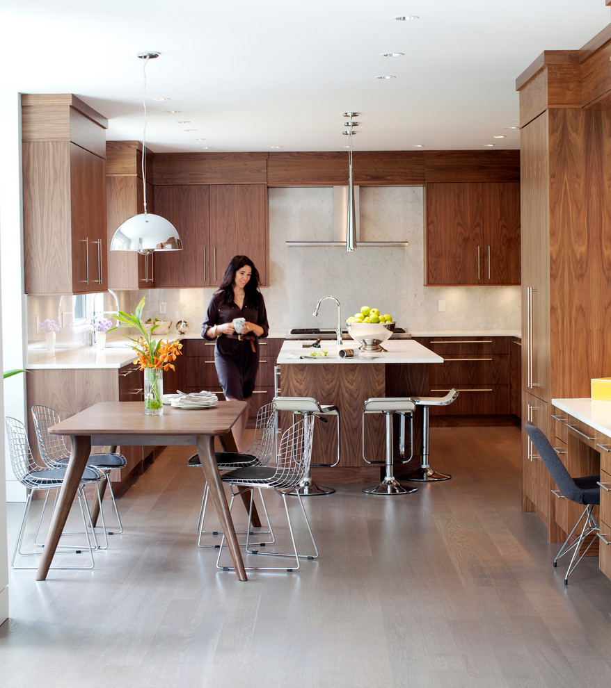 Example of a trendy l-shaped eat-in kitchen design in Vancouver with flat-panel cabinets, dark wood cabinets, white backsplash and stone slab backsplash
