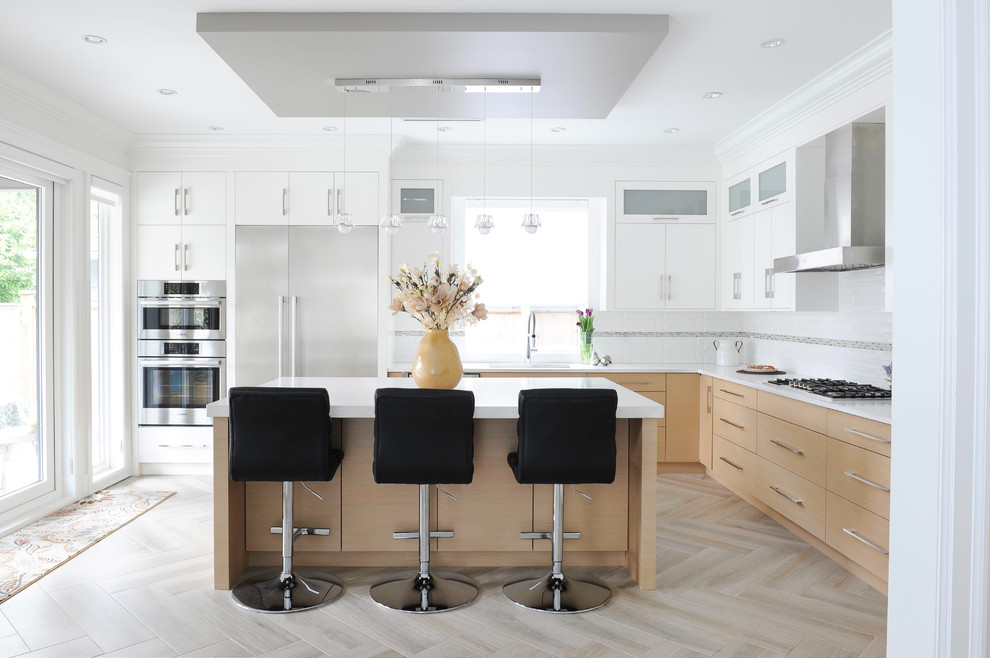 Large contemporary l-shaped kitchen in Vancouver with a submerged sink, flat-panel cabinets, engineered stone countertops, white splashback, porcelain splashback, stainless steel appliances, porcelain flooring, an island, white worktops, white cabinets and beige floors.