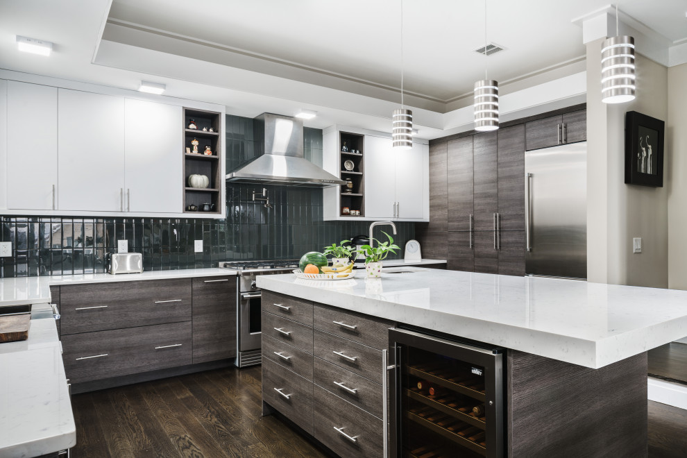 Esempio di una cucina minimal con ante lisce, ante grigie, paraspruzzi nero, elettrodomestici in acciaio inossidabile, parquet scuro, pavimento marrone e top bianco